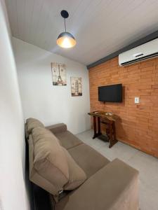 un salon avec un canapé et une télévision dans l'établissement Casa de São Francisco do Sul, à São Francisco do Sul