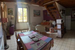 a living room with a table and chairs and a staircase at Le chalet des Robins in La Bergerie