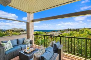 un patio con un sofá azul en el balcón en Kapalua Ridge Villas 1414 · KRV 1414 Remodeled 2BD Kapalua Vill, en Kahana