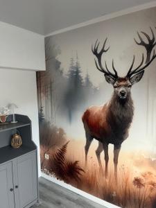 a painting of a deer on a wall in a room at Le refuge du Cerf in Bouillon