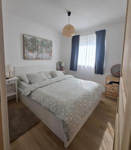 a white bedroom with a bed and a window at Kuća za odmor Brlog in Brlog