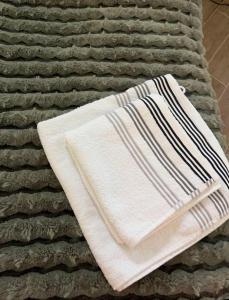 a white towel sitting on top of a bed at Studio Ohlendorf 3 Min zur A7 in Seevetal