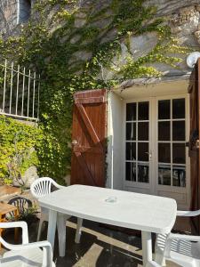 una mesa blanca y sillas frente a un edificio en La Parenthèse, en Bages