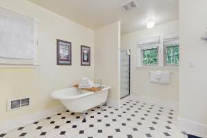 un bagno bianco con vasca e pavimento a scacchi di Port Townsend Perfection a Port Discovery Altre 13 foto