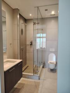 une salle de bains avec douche, toilettes et lavabo dans l'établissement Menlyn Maine Trilogy Apartment 1316 & 1316A, à Pretoria