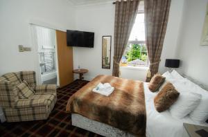 une chambre d'hôtel avec un lit et une chaise dans l'établissement Haughton Arms Hotel, à Alford 23 autres photos