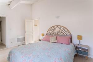 a bedroom with a large bed with pink pillows at Central Narbonne with rooftop terrace in Narbonne