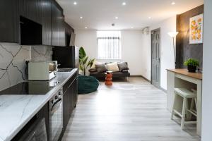 a kitchen with black cabinets and a living room at 4x Studio Apartments for Contractors, Professionals and Families near Coventry University, City Centre, BHX & NEC in Coventry +64 photos