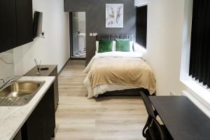 a bedroom with a bed with green pillows at 4x Studio Apartments for Contractors, Professionals and Families near Coventry University, City Centre, BHX & NEC in Coventry