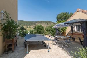 eine Tischtennisplatte im Hinterhof eines Hauses in der Unterkunft Appartement N°2 - Piscine Partagée in Lagorce