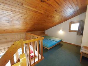 a attic room with a bed and a wooden ceiling at Duplex spacieux 3P à 20m des pistes, idéal famille, balcon, casier à skis - FR-1-356-269 in Valmorel