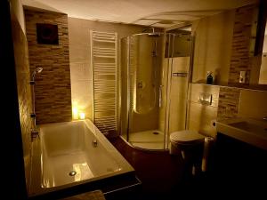 a bathroom with a tub and a shower and a sink at Tyrolyl - Ferienhaus Tirol in Inzing +75 photos