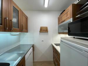 a kitchen with wooden cabinets and a counter top at Appart 4 pers, accès direct pistes, terrasse, 50m remontées - FR-1-356-426 in Valmorel