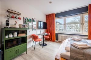 a bedroom with a bed and a table and a window at Klassen Stay - Design Apartments direkt am HBF Aachen in Aachen