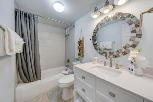 a bathroom with a sink and a toilet and a mirror at Menehune Shores 403 · MHS 403 Remodeled BeachFront 2BD Getaway in Kihei +46 photos