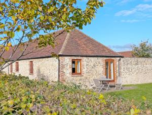 a brick house with a table and chairs in front of it at The Run, West Lavant in Chichester