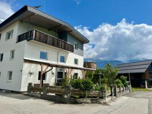 a white building with a balcony on top of it at Tyrolyl - Ferienhaus Tirol in Inzing