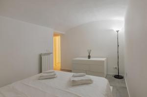 a white bedroom with a bed with towels on it at La casina di Camilla in Florence