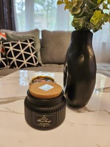 a black container sitting on a table next to a vase at Mostar Luxury Apartment in Mostar +3 photos