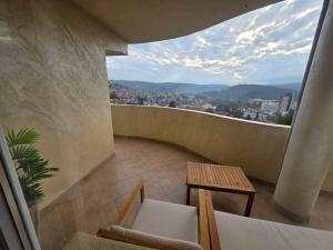 a room with a balcony with a table and chairs at Апартаменти Ванкови 2 in Veliko Tŭrnovo