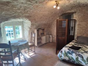 a bedroom with a bed and a table in a room at Le Relais Provençal in Barret-de-Lioure
