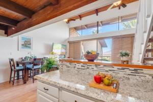 a kitchen with a counter with fruits on a cutting board at Kihei Alii Kai C405 · KAK C405 Updated 2BD Condo Across Beach w in Kihei