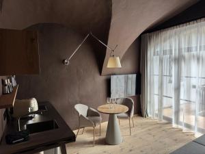 a kitchen with a table and chairs and a window at La Maison 35 - Bruneck in Brunico