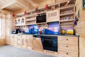 a kitchen with wooden cabinets and a black appliance at Zasypane Premium House & Sauna in Zakopane by Renters Prestige in Zakopane