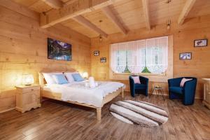 a bedroom with a bed and two blue chairs at Zasypane Premium House & Sauna in Zakopane by Renters Prestige in Zakopane +65 photos