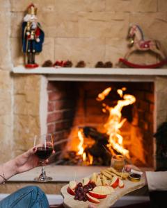 une personne tenant un verre de vin près d'une cheminée dans l'établissement Omodos Serenity House, à Omodos 18 autres photos