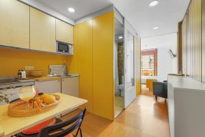 Una cocina con una mesa con un bol de fruta encima. en Abarco Apartments, en Santa Coloma
