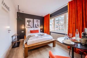 a bedroom with a bed and a table and a dining room at Klassen Stay - Design Apartments direkt am HBF Aachen in Aachen