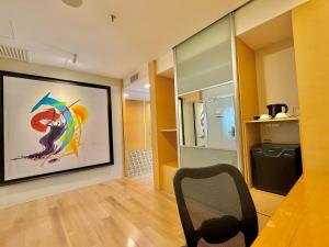 a living room with a chair and a painting on the wall at NuEmpire Subang Suite - Empire Hotel in Subang Jaya