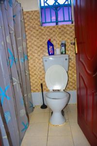 a bathroom with a white toilet in a room at Zariah Homes in Kakamega