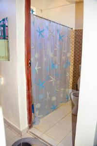 a bathroom with a shower curtain with blue butterflies at Zariah Homes in Kakamega