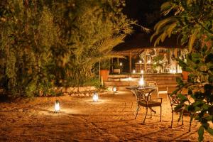 a table and chairs in a yard at night at Ohorongo Safari Lodge in Kamanjab