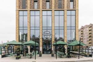 a large brick building with tables and green umbrellas at The Social Hub Eindhoven in Eindhoven +28 photos