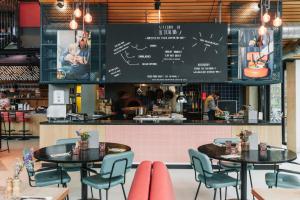 a dining room with two tables and a kitchen at The Social Hub Eindhoven Extended Stay in Eindhoven