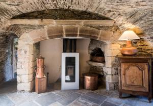 a stone archway with a white door in a room at Le Prieuré de Saint Sauveur - Climatisation - Séjour Nature & Détente in Comps-la-Grand-Ville