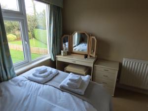 a bedroom with a mirror and a bed with towels at The Flat in Broughton