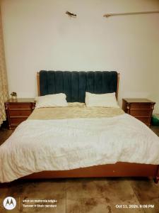 a large bed with a green headboard in a bedroom at Comfort Suites Karachi in Karachi