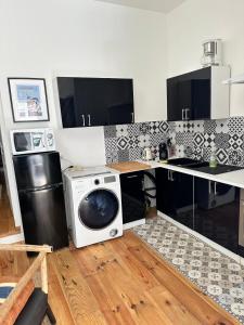 eine Küche mit Mikrowelle und Waschmaschine in der Unterkunft Le Havre Coty proche plage Hyper centre in Le Havre