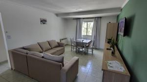 a living room with a couch and a table at Departamento Costa Del Sol - 2 dormitorios in Neuquén +7 photos