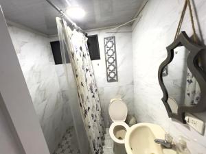 a bathroom with a toilet and a sink at Como en casa apartment in Cali