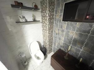 Un baño con inodoro y un televisor en la pared. en Como en casa apartment, en Cali