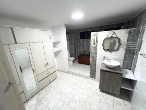 Un baño con lavabo, ducha e inodoro. en Como en casa apartment, en Cali