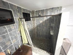 a bathroom with a shower with a stone wall at Como en casa apartment in Cali +3 photos