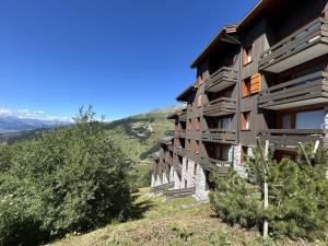 a building on the side of a hill with trees at Studio confortable, casier à ski, proche pistes, Méribel - FR-1-355-164 in Les Allues +8 photos