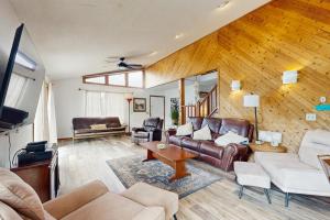a living room with leather furniture and wooden walls at Seascape in Folly Beach
