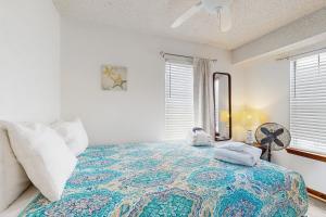 a bedroom with a large bed and a fan at Seascape in Folly Beach